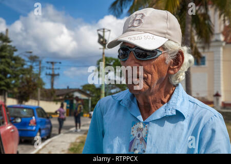 La Havane, Cuba - 12 janvier 2013 : une vue sur les rues de la ville avec des cubains. Un portrait du vieil homme en casquette et lunettes de soleil. Banque D'Images