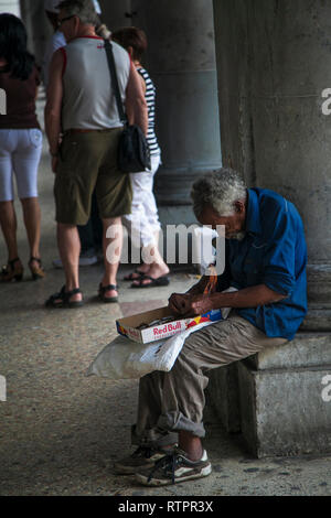 La Havane, Cuba - 21 janvier 2013 : une vue sur les rues de la ville avec des cubains. Un très vieil homme fait des cigarettes. Banque D'Images