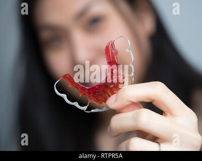 Portrait of beautiful Asian woman holding patient dans les retenues d'orthodontie clinique dentaire, Smiling Girl Holding blue la retenue, accolades pour les dents. Banque D'Images