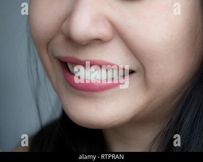 Photo de gros plan femme asiatique chinois Thai visage Maquillage féminin. Femme avec des lèvres rouge à lèvres rouge et blanc grand dentaire saine dents parfaites. Dental Banque D'Images