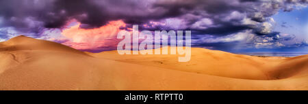 Cloudscape épais de vives couleurs de la lumière du soleil au coucher du soleil pendant le temps d'assaut sur des dunes de Stockton Beach avec l'océan Pacifique lointain derrière sa Banque D'Images