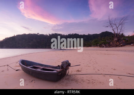 Petit bateau sur la plage au crépuscule du temps. Banque D'Images