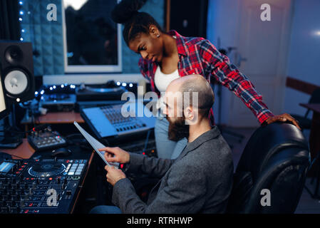 Ingénieur du son barbu au panneau de télécommande en studio d'enregistrement audio. Musicien à la console de mixage de musique professionnels, Banque D'Images