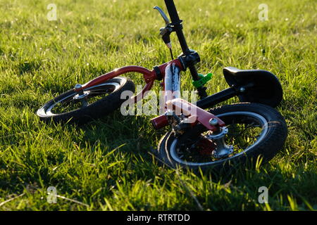 Vélo enfant couché sur l'herbe, après-midi ensoleillé Banque D'Images