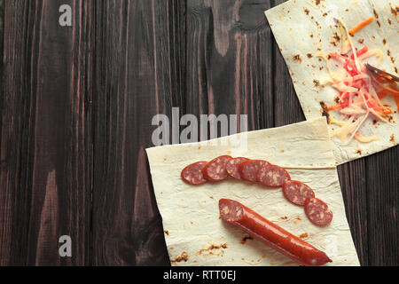 Préparation de salami dans un pita.photo sur un fond de bois Banque D'Images