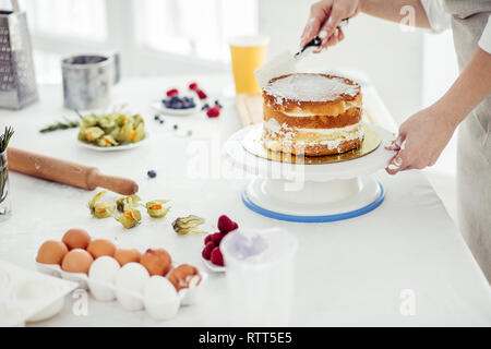 Chef de l'assemblage des couches de gâteau. détail les initiatives sur la façon de faire de gâteau, Close up photo recadrée Banque D'Images