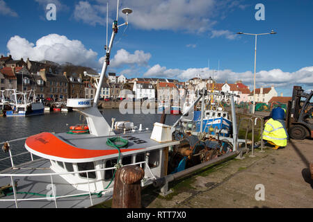 Deux pêcheurs travaillant sur un chalutier amarré dans le beau port de Pittenweem dans le Fife sur la côte est de l'Ecosse Banque D'Images