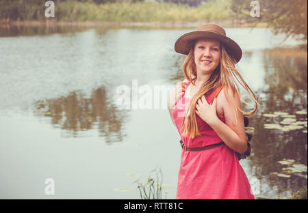Voyageur adolescent fille marche à côté de la rivière avant la pluie Banque D'Images