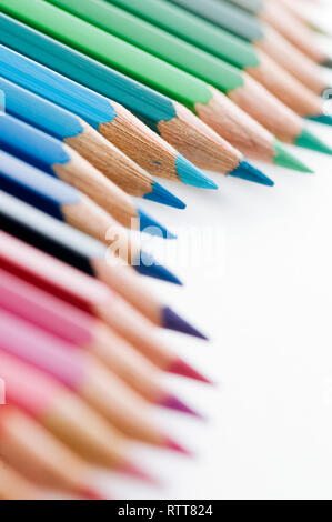 Crayons de couleur ondulée de Gros plan sur fond blanc avec l'accent sur les stylos bleu en haut photo tiers. Banque D'Images