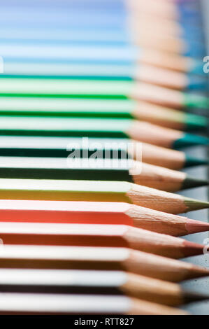 Close close-up de crayons de couleur horizontales parallèles sur fond blanc avec l'accent sur le crayon de couleur chair dans le coin inférieur droit tiers. Banque D'Images