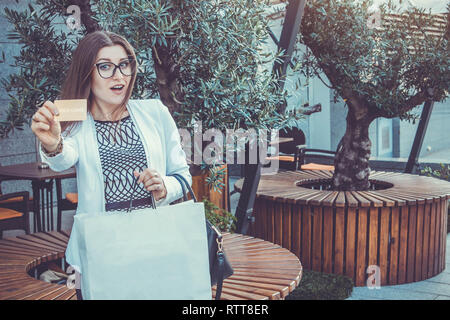 Belle femme a l'achat avec une carte gold. Girl holding shopping bags Banque D'Images