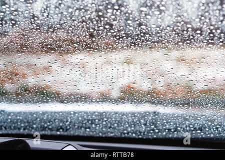 Goutte d'eau sur une vitre de voiture, la pluie tombe sur le verre Banque D'Images