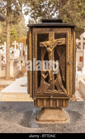 Scène de crucifixion sur une lampe en laiton dans un cimetière. Libre de photo avec un fond diffus. Banque D'Images