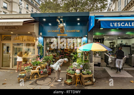 Une femme à la fleur à l'affiche à la garde champêtre, un fleuriste et marchande de fleurs sur Rue des Martyrs , St Georges , Paris Banque D'Images