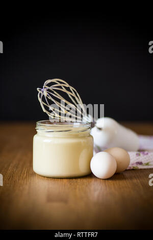 Mayonnaise maison dans un bocal en verre sur une base en bois Banque D'Images