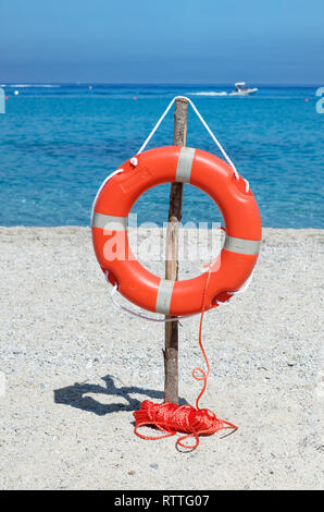 Bouée orange sur la plage de sable contre la mer bleue de l'eau. Plage de Riaci près de Tropea, Italie Banque D'Images