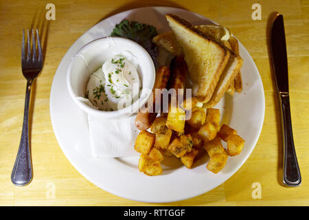 Un petit-déjeuner servi au Manitoba, Canada. Il dispose d'un oeuf poché, saucisses, pain grillé et l'empreinte des pommes de terre. Banque D'Images