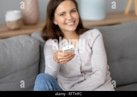 Souriante jeune femme avec l'air conditionné à la maison Banque D'Images