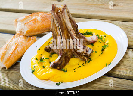 Délicieux agneau cuit sur l'os (Pinnekjott) servi avec une purée de rutabaga, de vert et de pain frais. Une cuisine norvégienne Banque D'Images