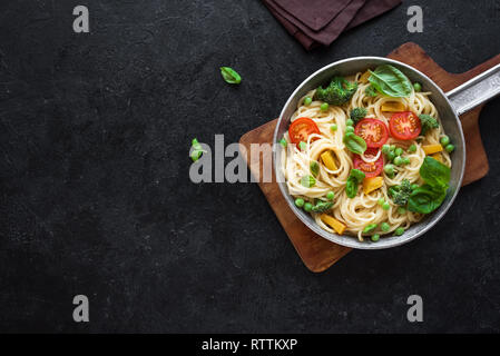 Pâtes Primavera. Les pâtes Spaghetti aux légumes et basilic, vue du dessus, copiez l'espace. Recette de saison végétarien Pâtes Primavera. Banque D'Images