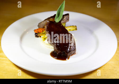 Steak recouvert d'un jus et servi dans les régions rurales du Manitoba, Canada. La viande est servi avec des légumes. Banque D'Images