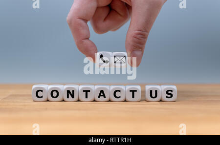 Construit dés les mots 'contactez-nous', tandis qu'une main tient deux dés avec un symbole d'un téléphone et d'une lettre. Banque D'Images