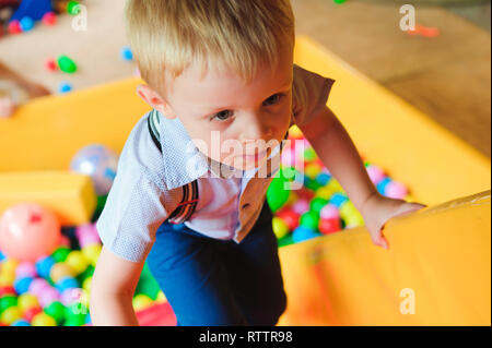 Garçons jouant sur l'aire de jeux, dans le labyrinthe des enfants avec des ballons. Balles multicolores Banque D'Images