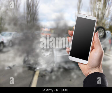 Avec le téléphone main de femme sur fond d'un accident de voiture Banque D'Images