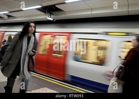 London Underground tube train en mouvement et passagère marcher le long de la plate-forme à la gare de Brixton, dans le sud de Londres UK KATHY DEWITT Banque D'Images