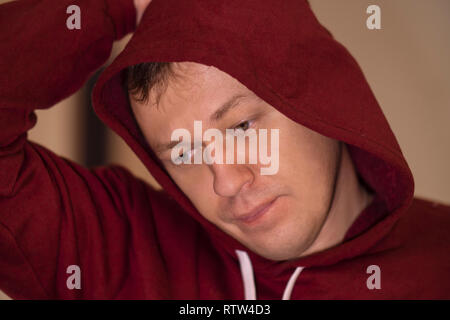 Portrait d'un jeune homme dans une hotte, réfléchi regardez, close-up Banque D'Images