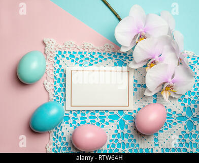 Les oeufs de pâques bleu rose sur un fond de couleur pastel avec un espace réservé au texte la dentelle et orchid Banque D'Images