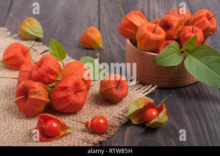 Physalis éparpillés sur une table en bois foncé Banque D'Images