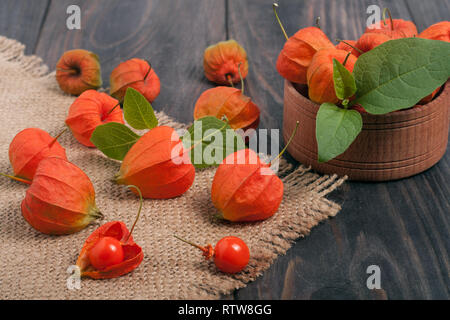 Physalis éparpillés sur une table en bois foncé Banque D'Images