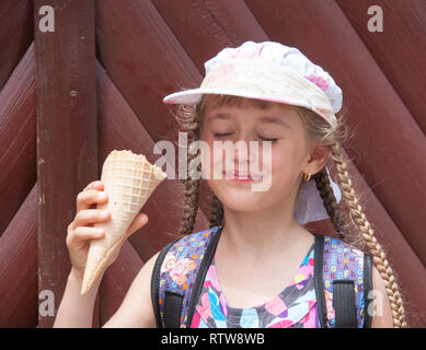 Fille dans un capuchon mange la crème glacée Banque D'Images