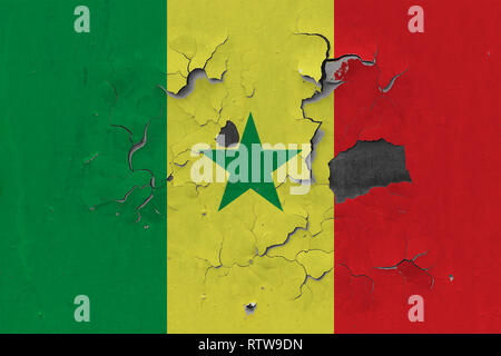 Close up grungy, endommagés et traversé le Sénégal drapeau sur mur peinture écaille pour voir la surface de l'intérieur. Banque D'Images