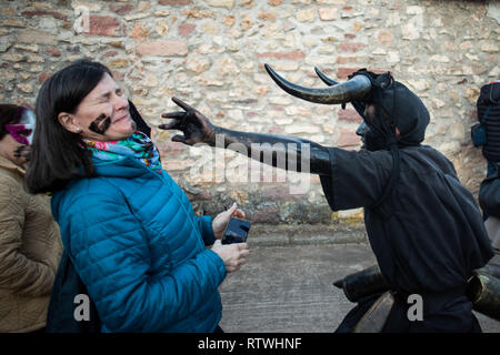 Luzon, Guadalajara, Espagne. 2e Mar, 2019. Un homme s'habiller comme un 'Diablo' est vu la peinture d'une femme joue avec de l'huile et de suie pendant les diables de Luzon Carnaval. Des centaines de personnes à célébrer l'antique tradition de la Fête des diables et Figures masquées. Les gens s'habillent comme des diables avec des cornes de taureau, cloches et peindre leur corps avec l'huile et de suie noire. Porter des masques blancs des fêtards. La tradition remonte au 14e siècle. Crédit : Bruno Thevenin/SOPA Images/ZUMA/Alamy Fil Live News Banque D'Images