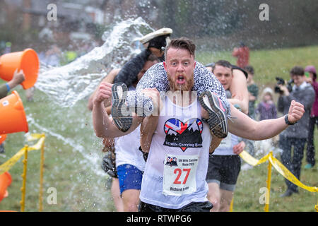 Dorking, UK, 3 mars 2019, maris, amis portent leurs êtres chers pour le sommet de la colline et sur les 380 mètres de course pour une médaille et un fût de bière pendant le UK Femme transportant des championnats qui ont lieu à Dorking, Surry , Royaume-Uni.© Jason Richardson / Alamy Live News. Banque D'Images