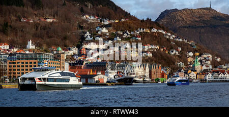 Catamarans à passagers à grande vitesse Njord et Rygercruise au départ du port de Bergen, Norvège. Et le mont Floyen, Bryggen et Ulriken dans le background Banque D'Images