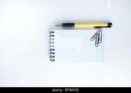 Le bloc-notes, stylo et papier clip sur fond blanc .photo avec copie espace Banque D'Images