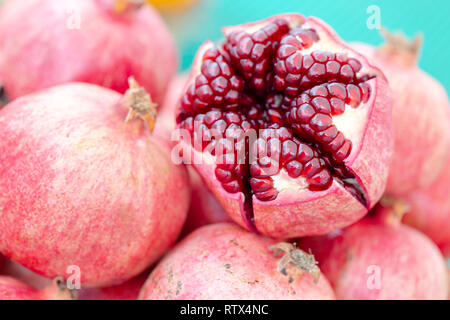 Pelées, coupées en deux dans grenade couleur corail vivant avec bold seeds on market stall. Détaillé, Close up shot Banque D'Images