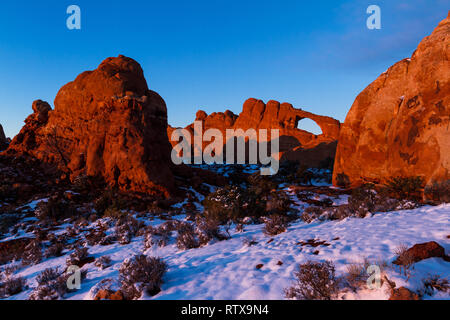 Magnifique coucher de soleil avec fenêtre nord par le coucher de soleil rougeoyant qui rebondissent sur la roche rouge avec un peu de neige dans le sol Banque D'Images