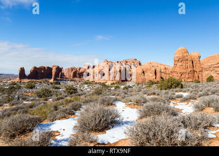 Scène enneigée à Arches NP avec de belles caractéristiques des roches rouges contrastant avec le ciel bleu Banque D'Images