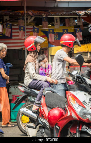 Couple avec petit enfant en scooter à Kuala Lumpur Malaisie Banque D'Images