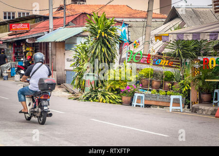 Man riding moped motorbike dans street à Kuala Lumpur, en Malaisie Banque D'Images