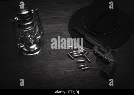 Old western souffle froid d'une lanterne et d'un revolver à cartouches sur table en bois Banque D'Images