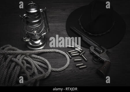 Old western souffle froid d'une lanterne et d'un revolver à cartouches sur table en bois Banque D'Images