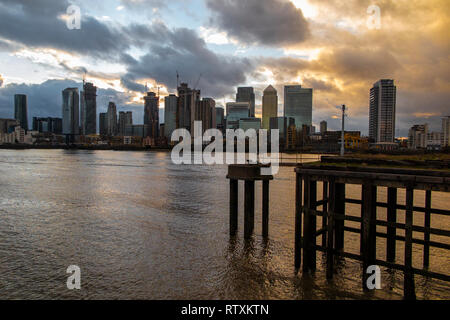 Le soleil se couche derrière les différents buildings des Docklands sur un jour de tempête Banque D'Images