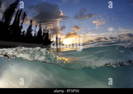 Vague se casse au lever du soleil dans la côte de la baie de Kanumera, Iles des Pins, Nouvelle Calédonie, du Pacifique Sud Banque D'Images