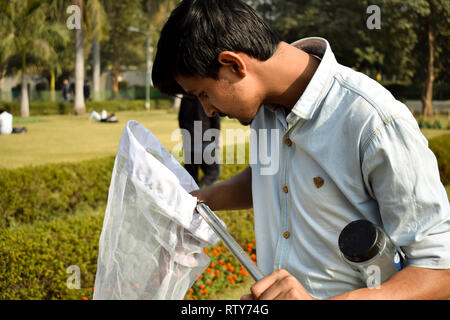 Jeune homme la collecte à l'aide d'un entomologiste Insectes Insectes net ou de la glisser pour sa collecte de spécimens d'insectes pendant un été lumineux Banque D'Images