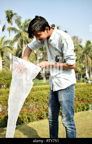 Jeune homme la collecte à l'aide d'un entomologiste Insectes Insectes net ou de la glisser pour sa collecte de spécimens d'insectes pendant un été lumineux Banque D'Images